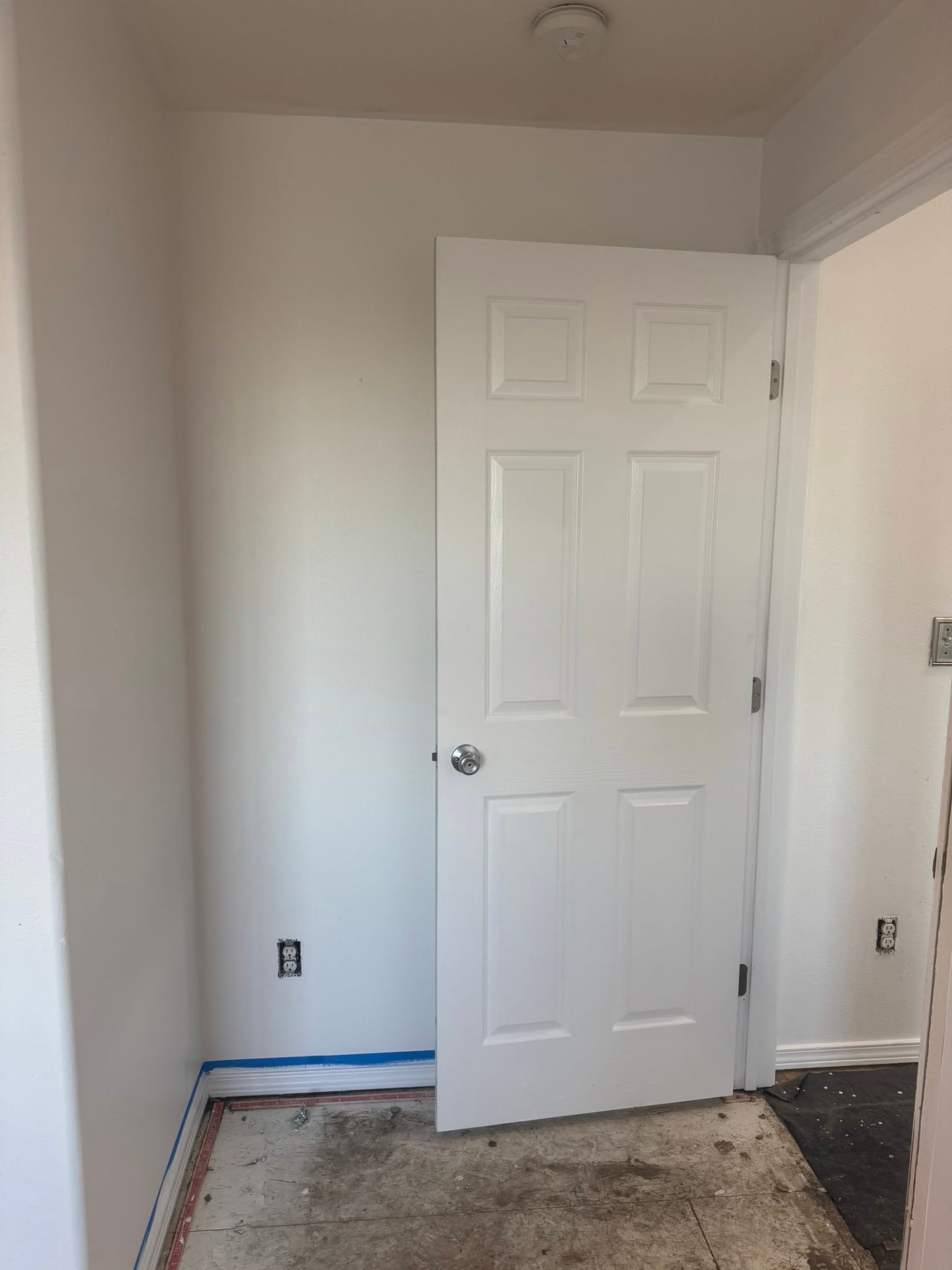 Interior painting with fresh white walls, door, and baseboard